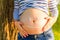 Belly of a pregnant woman painted cheerful smiley