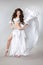 Bellydance. Beautiful belly dancer woman in white shining costume with blowing fabric. Long healthy curly hair. arabian