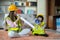 A beloved Asian mother and daughter pretend to be an engineer and smile with a safety hat in the house