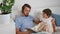 beloved father reads a book to his son in a white bed