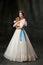 Beloved pet. Portrait of young charming woman in white vintage dress as medieval princess holding small King Charles