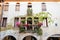 Below frontal view of medieval italian building with flowers and arcade and ivy on the walls on summer day sunset