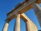 From below shot of amazing columns of antique ruined building against clear blue sky on sunny day.