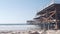 Below wooden Crystal pier on piles, ocean beach water waves, California USA.