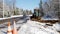 BEMIDJI, MN - 22 NOV 2019: Orange cones warn traffic of a utility work zone as a backhoe operator pounds dirt into a trench along