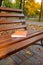 A bench in City park, Golden hour. Autumn: old book on the bench