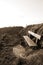 Bench on a cliff edge at sunset in sepia