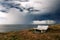 Bench on cliff with storm over sea