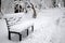 Bench covered with snow in the city park in winter