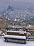 Bench covered in snow and view to Olympus mountains. Litohoro in Pieria, Greece at winter time