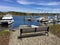 Bench in harbor with boats on coast in central maine