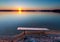 Bench on lake shore at sunset