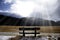 Bench looking solitary at frozen Sils lake in Engadin Switzerland with snow Alps mountains