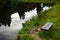 A bench made of boards on the shore of a pond near the church