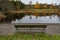 Bench overlooking calm water and autumn forest