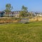 Bench on a park with homes and sky in background