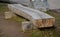 A bench in a park made of one half of a massive trunk. It is a heavy wooden product with a natural, durable appearance. Large ston