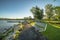 Bench on a park overlooking a scenic lake with wooden deck and bridge