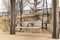 Bench pergola in park alongside stone brick wall on gravel walkway