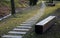 Bench prism of one piece of trunk painted in the park pedal road made of concrete tiles in lawn straight row concrete walkway in c
