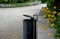 Bench at a retaining wall in a park of black bushes early spring perennials on a high flowerbed path of granite cubes