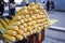 Bench selling boiled corn. Boiled corn and hot water in the boiler. Uncooked raw corns in front of countertop