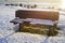 Bench on the shore of an snow covered lake