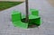 Bench sitting with a hole around a tree. green painted metal perforated plate. three places around the tree around like a pizza or