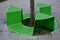 Bench sitting with a hole around a tree. green painted metal perforated plate. three places around the tree around like a pizza or