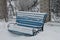 Bench in the snow in a winter church park