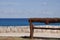 Bench, stone fence and blue sea