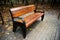 Bench in the summer park with old trees and footpath