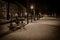 Bench between trees at snowy path at night  with historic dutch buildings and man sitting