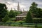 Benches, public toilet, trees and hedges in Volksgarten in Vienna with City Hall in Backgounrd