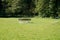 Benches and a table in the middle of a green meadow for picnic