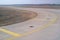 Bend in airport taxiway. Yellow markings, day, no people