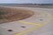 Bend in airport taxiway. Yellow markings, day, no people