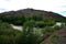 A bend of a calm river, the banks overgrown with forest, flowing through a picturesque valley at the foot of a high mountain