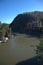 The bend of a calm river flowing between mountains under a clear sky