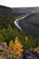 A bend of the Irgina River in a deep river valley among a bright autumn forest. In the foothills of the Western Urals, golden autu