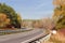 Bend of the motorway with forest on both sides autumn