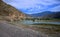 The bend of a mountain turquoise river at the foot of high hills