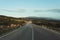 Bending country road with windmills on the hills