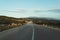 Bending country road with windmills on the hills