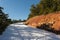 Bending mountain road with snow among the pine trees