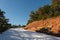 Bending mountain road with snow among the pine trees