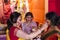 Bengali married women in white sari playing sindoor or sindur khela, traditional Bengali ritual of applying vermilion to faces,