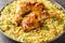Bengali style roast chicken legs with fried onions served with spicy pilaf close up in a plate. Horizontal