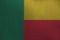 Benin flag depicted in paint colors on old brushed metal plate or wall closeup. Textured banner on rough background