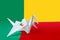 Benin flag depicted on paper origami crane wing. Handmade arts concept